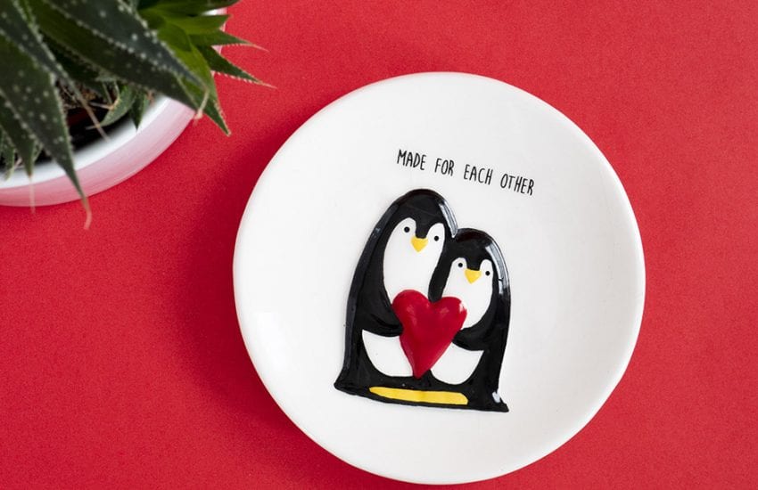 small penguin dish with a plant against red background